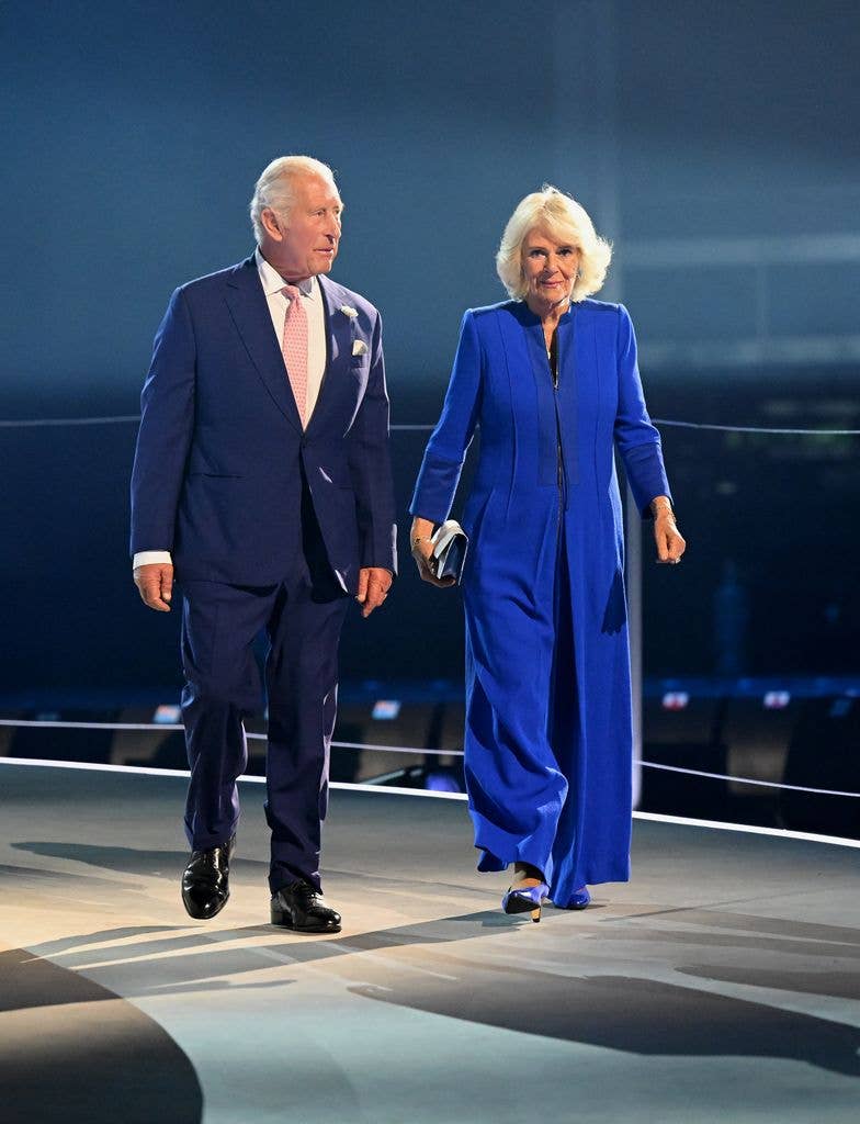 King Charles and Queen Camilla walk on stage during the opening ceremony