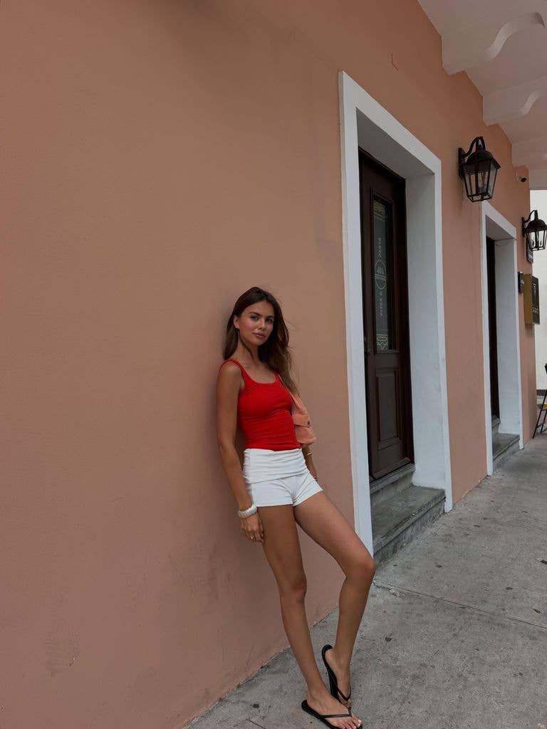 Alex in red top and white shorts
