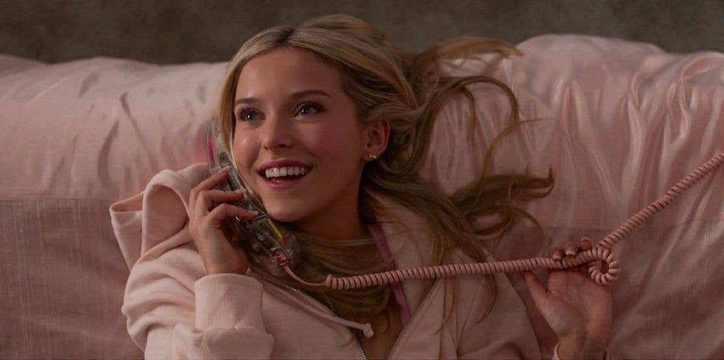 young woman lying on bed on phone