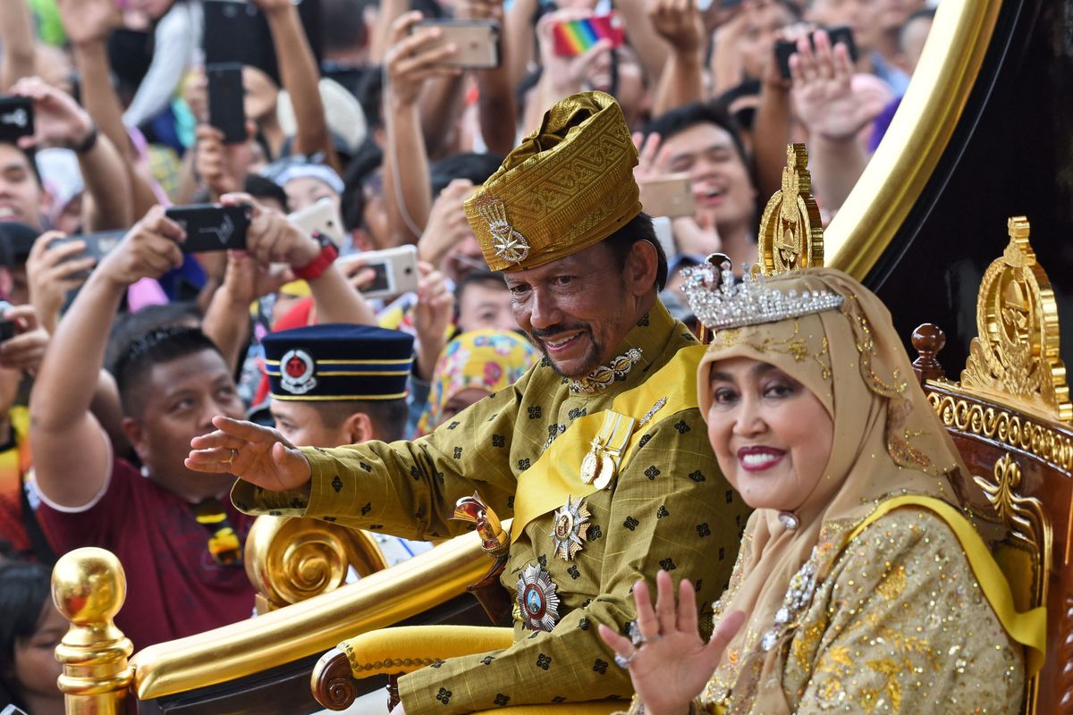 Brunei's Sultan Hassanal Bolkiah and Queen Saleha ride in a royal chariot during a procession to mark his golden jubilee of accession to the throne in Bandar Seri Begawan on October 5, 2017