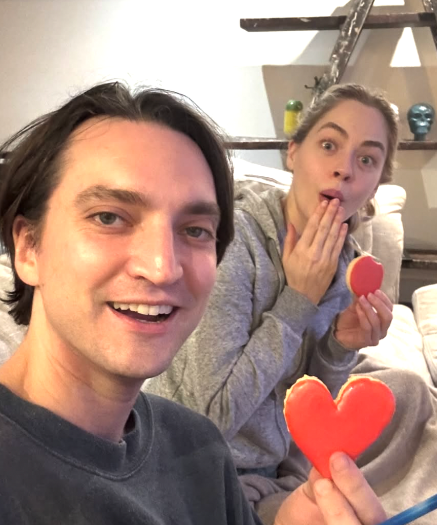 The happy couple smiling as they held heart-shaped treats