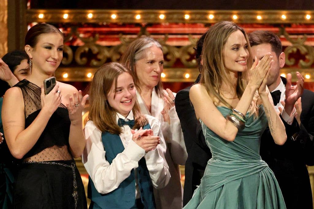 Vivienne Jolie (2L) and mom Angelina Jolie and cast and crew accept the Best Musical award for "The Outsiders" onstage during The 77th Annual Tony Awards 