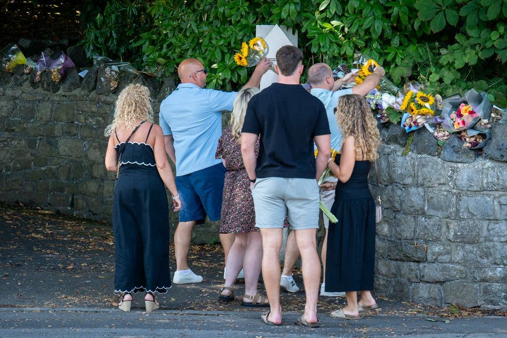 People leave floral tributes outside the home of Bonnie Tyler ahead her coffin arriving at her home on Mumbles Road 