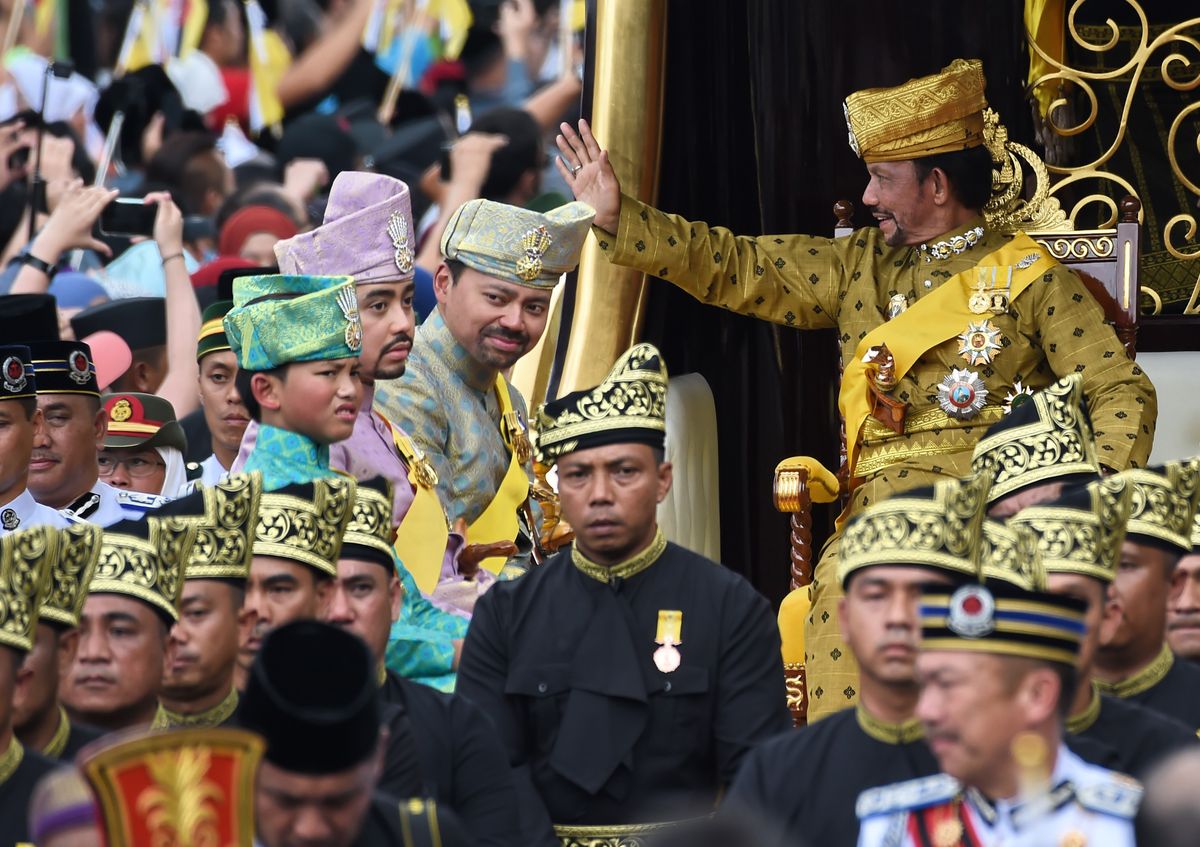 Brunei's Sultan Hassanal Bolkiah (R) waves while Crown Prince Al-Muhtadee Billah (2nd R), Prince Abdul Malik (2nd L) and Prince Abdul Wakeel (L) look on from the royal chariot during a procession to mark his golden jubilee of accession to the throne in Bandar Seri Begawan on October 5, 2017. 
