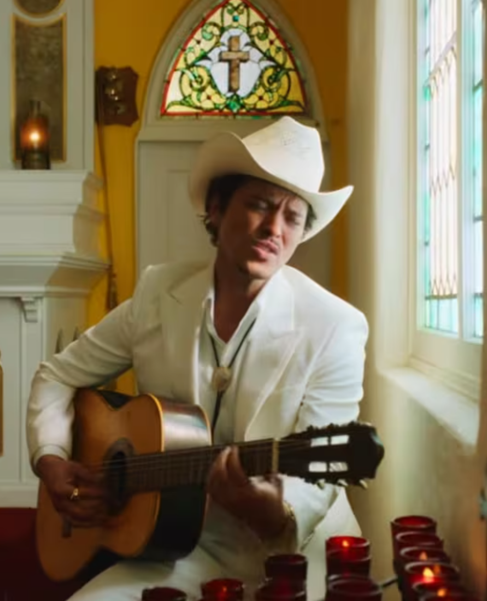 The video opens with Mars standing at the altar of a beautifully decorated church inspired by traditional Mexican architecture. 