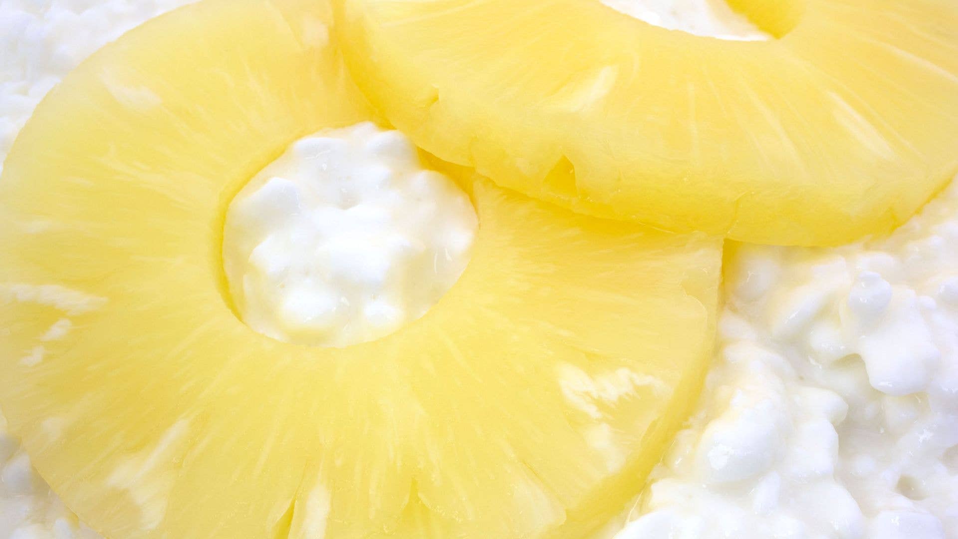 Two pineapple rings on top of a bed of white cottage cheese.
