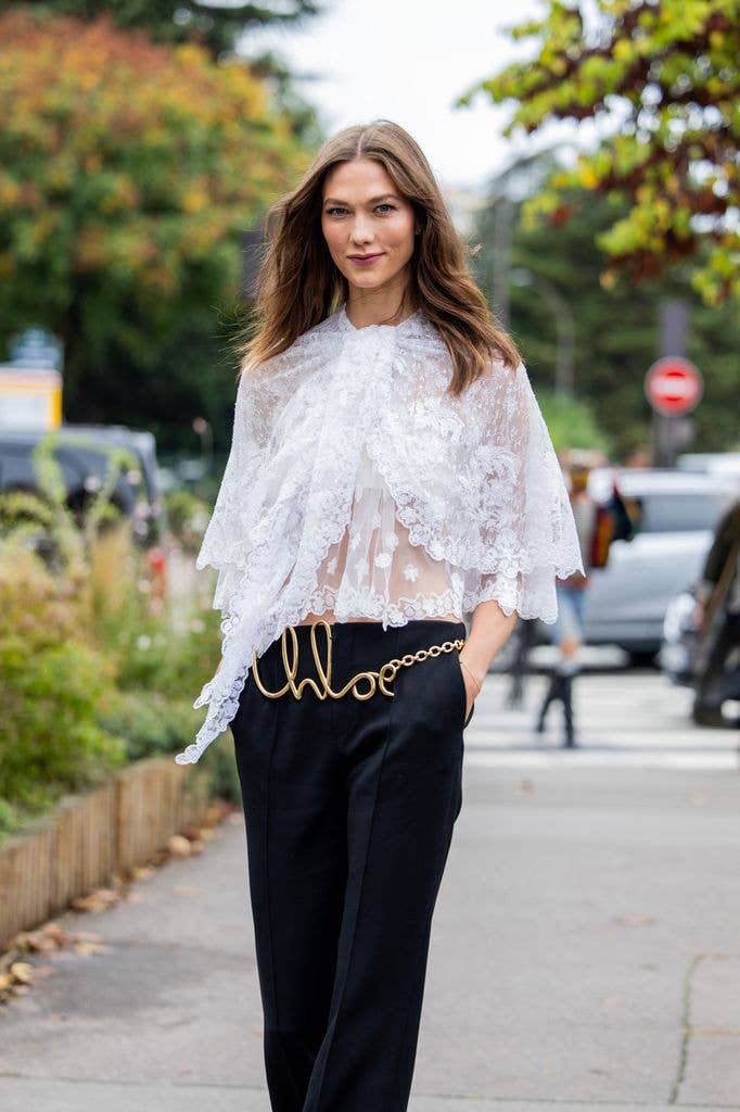 Karlie Kloss wears a white Chloe blouse during Paris Fashion Week 
