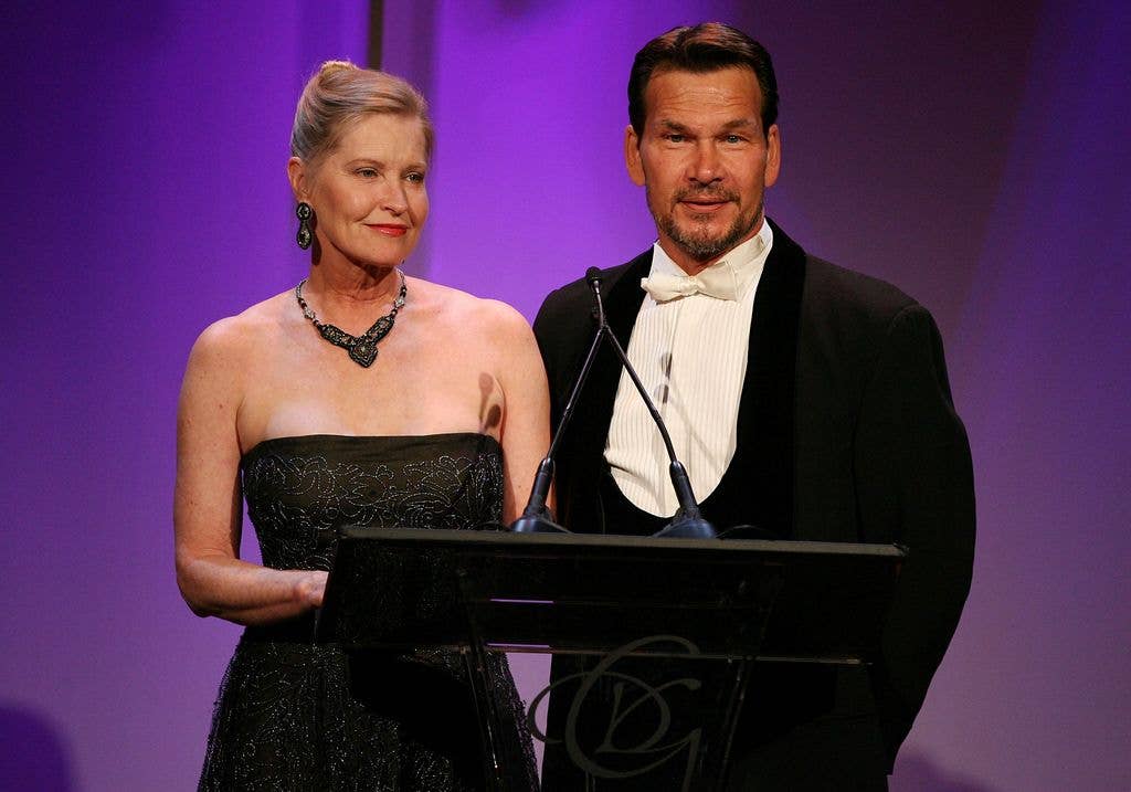 Lisa Niemi and actor Patrick Swayze speak onstage behind a podium during the 9th annual Costume Designers Guild Awards.