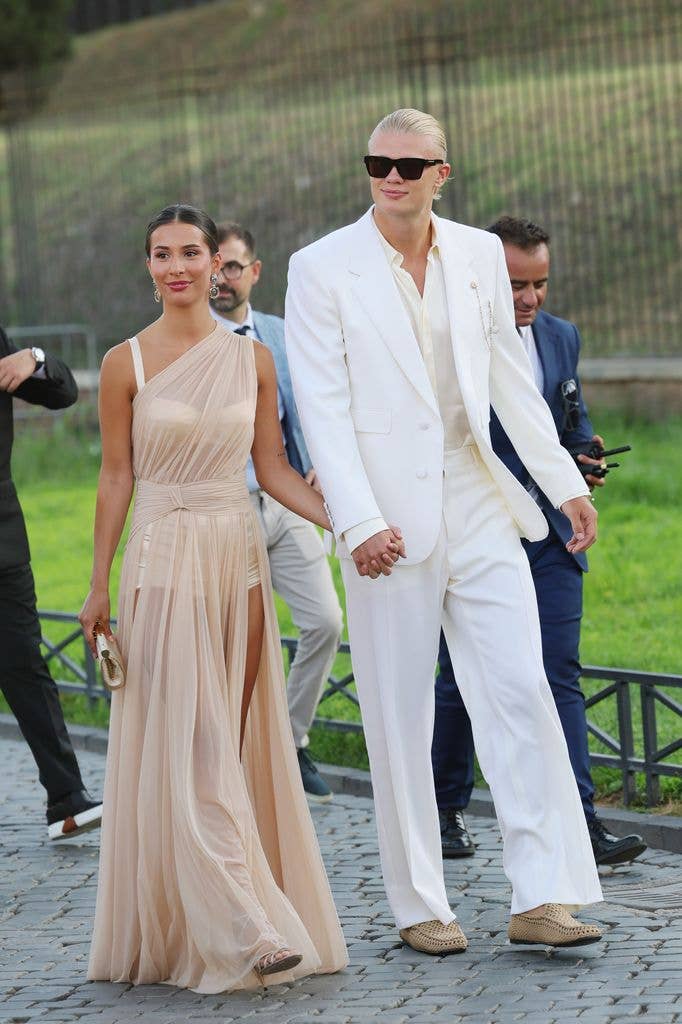  Isabel Haugseng Johansen and Erling Haaland are seen outside the Dolce & Gabbana Alta Moda fashion show at Foro Romano in white suit