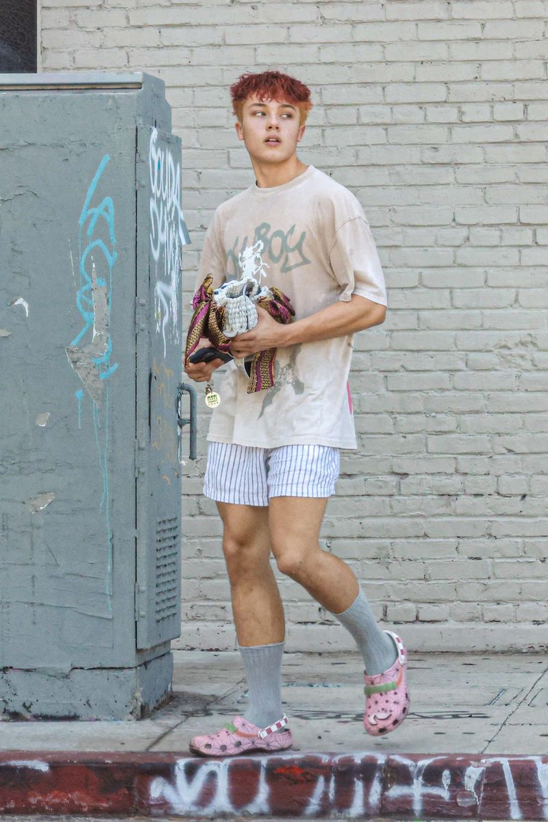 The teenager’s colorful footwear complemented the vivid rose-red tones of his latest hairstyle.