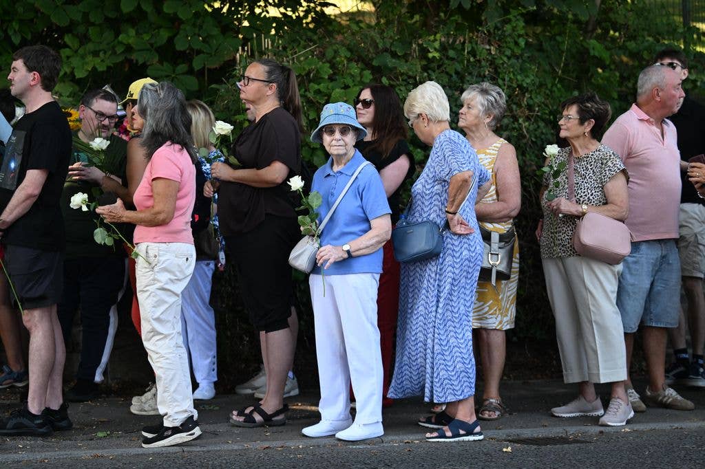 People leave floral tributes outside the home of Bonnie Tyler ahead her coffin arriving at her home on Mumbles Road 
