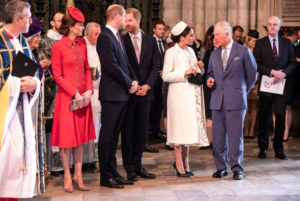 Prince Harry and Meghan, Duchess of Sussex, stand with Charles, Prince of Wales, at an event.