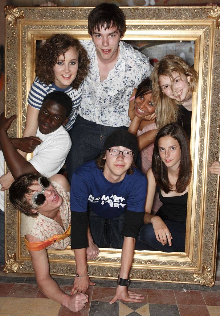 Group of young actors, including Kaya Scodelario and Nicholas Hoult, posing in a large ornate frame.