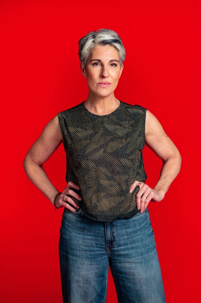 woman with hands on hips against red background