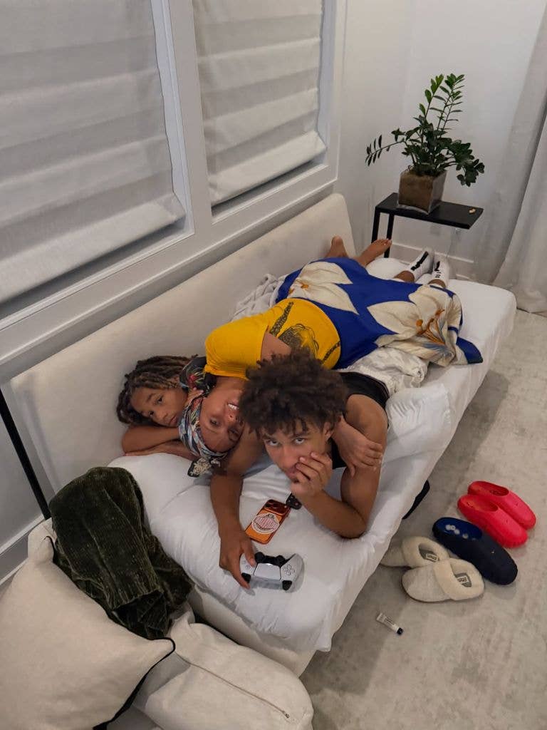 Alicia Keys lying on a sofa with her two sons