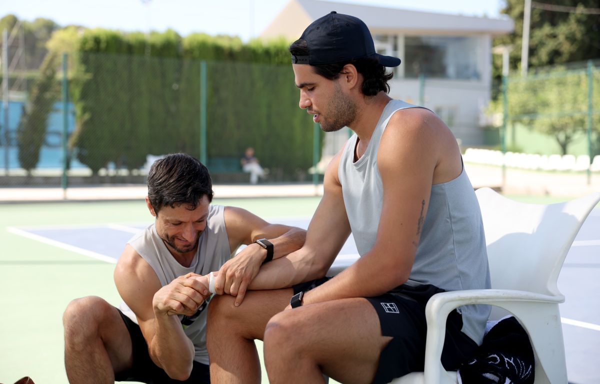 His physio, Juanjo Moreno, performs wrist stretching exercises before a practice session at Real Sociedad Club De Campo on August 04, 2026 
