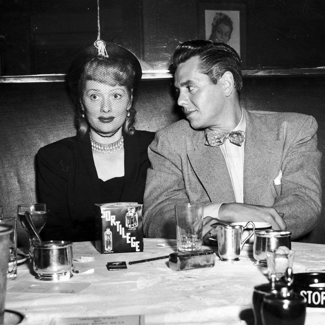 American actress Lucille Ball (1911 - 1989) with her husband Desi Arnaz (1917 - 1986) at the Stork Club in New York City, circa 1945. Lucille has a bottle of the club's house perfume, Sortilege.
