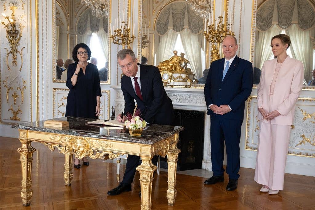 charlene and albert in palace watching man sign papers