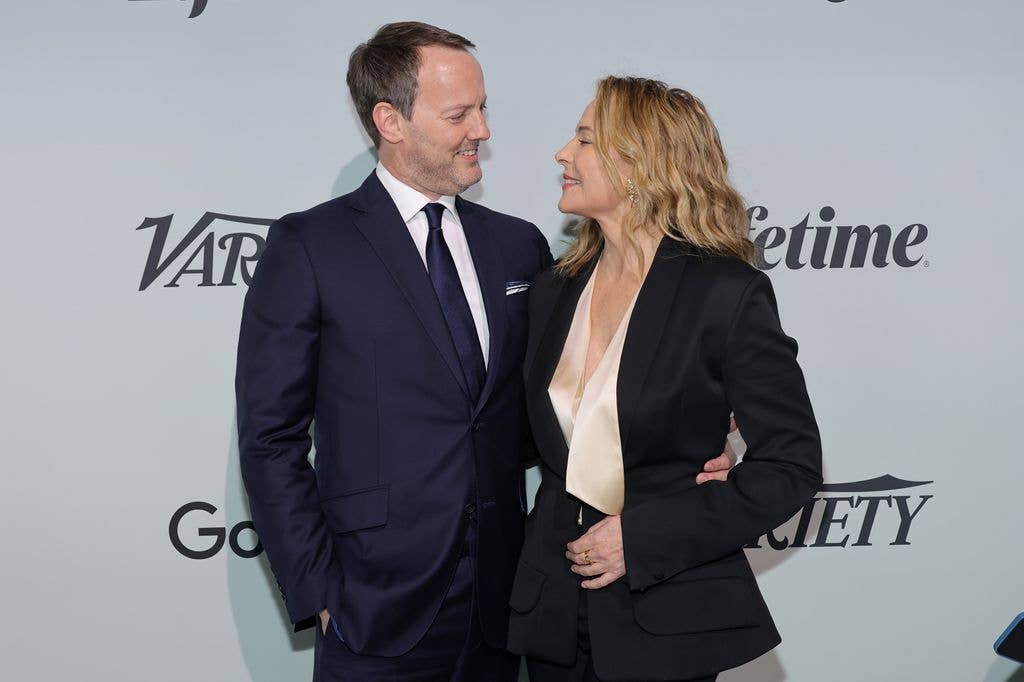 Kim Cattrall and Russell Thomas looking at each other and smiling on a red carpet