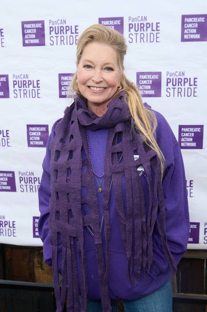 Lisa Niemi in a purple jumper and purple scarf, holding her hands in her pockets.
