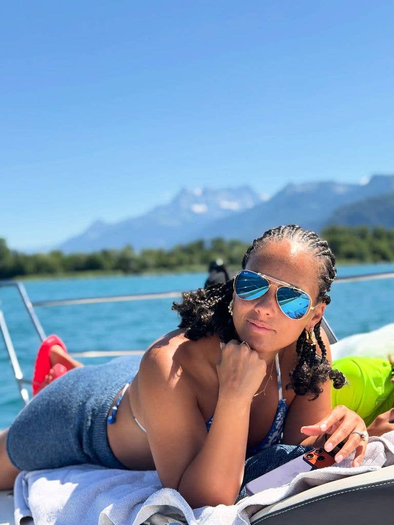 Alicia Keys lying on a boat wearing bikini and sunglasses