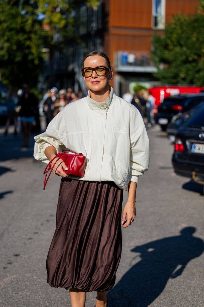 Tina Haase wears white jacket, brown skirt, red bag outside Gestuz during the Copenhagen Fashion Week 
