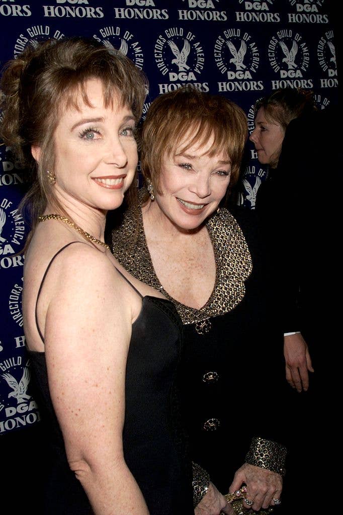 Shirley MacLaine and Sachi Parker smiling at an event, both wearing elegant black dresses.