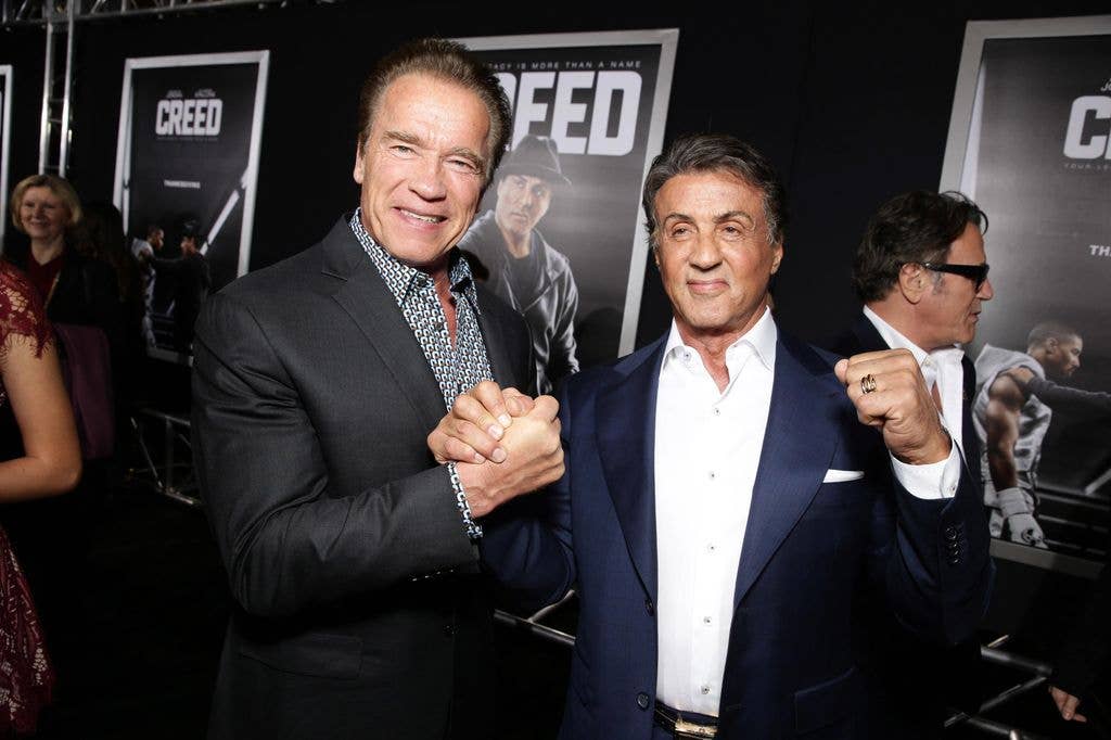 Arnold Schwarzenegger and Producer Sylvester Stallone holding hands