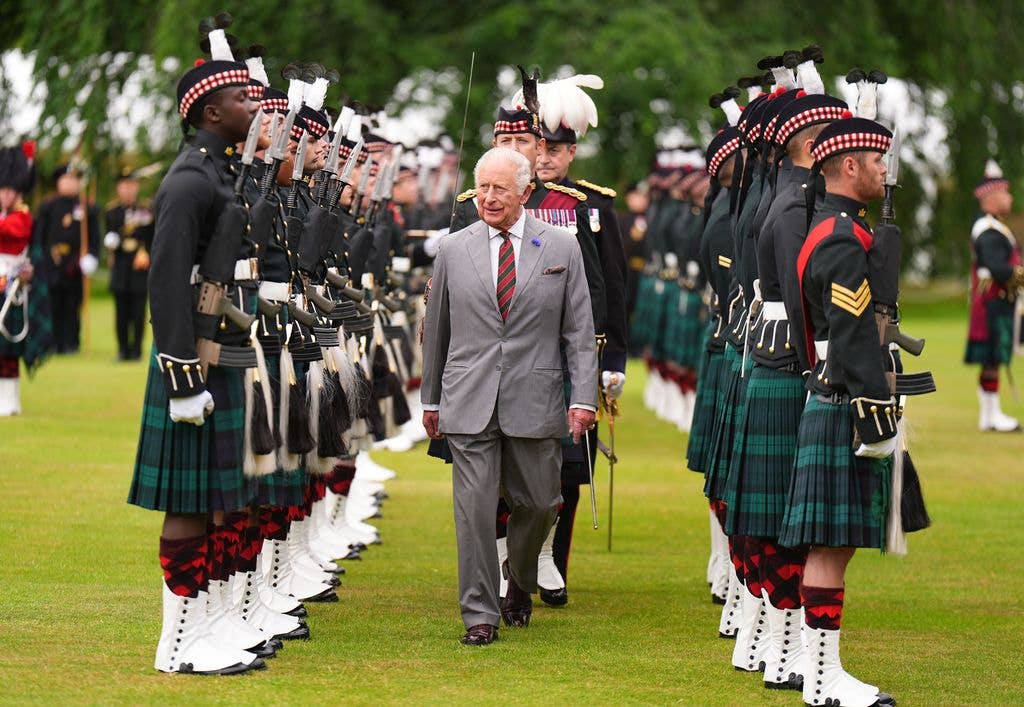 King Charles walks inbetween guards