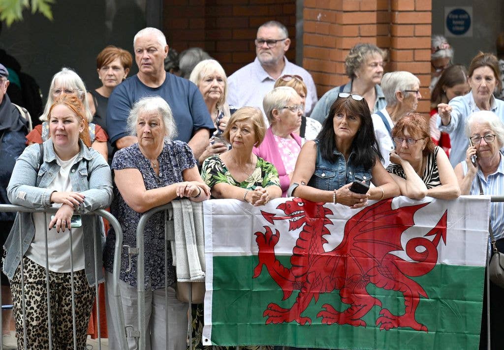 Mourners bear the Welsh flag