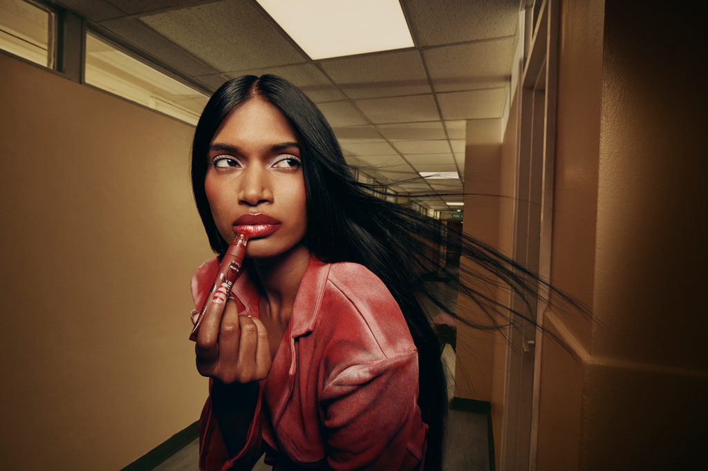 model applying rimmel london lip balm