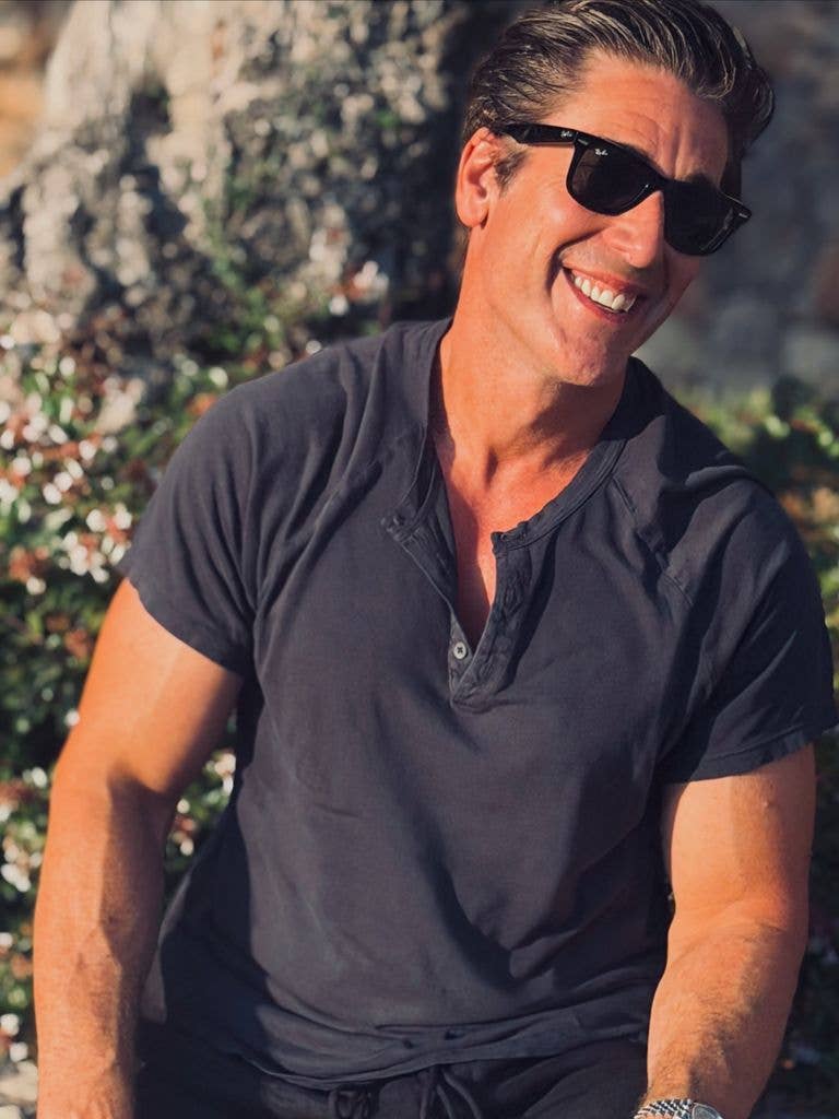 David Muir smiling looking casual in a pair of sunglasses and t-shirt
