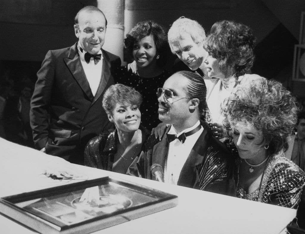 Dionne Warwick, Stevie Wonder, Elizabeth Taylor, Gladys Knight, Burt Bacharach and Carole Bayer Sager at a performance of the song 'That's What Friends Are For' on the television show 'Solid Gold' in Los Angeles, USA, 1986. On the left is Clive Davis, President of Arista Records. The proceeds from the song's sale will go to amFAR, the American Foundation for AIDS Research.