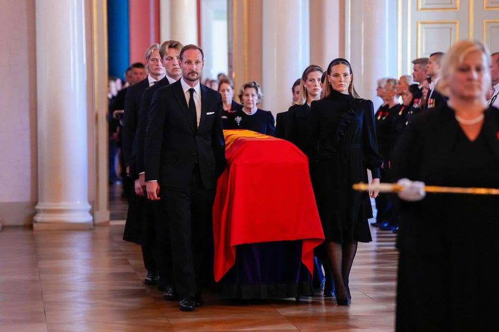 Chief of the Court Olav Heian-Engdal walks in front of the procession, carrying the royal crown on a cushion, followed by the royal sword and the king's orders