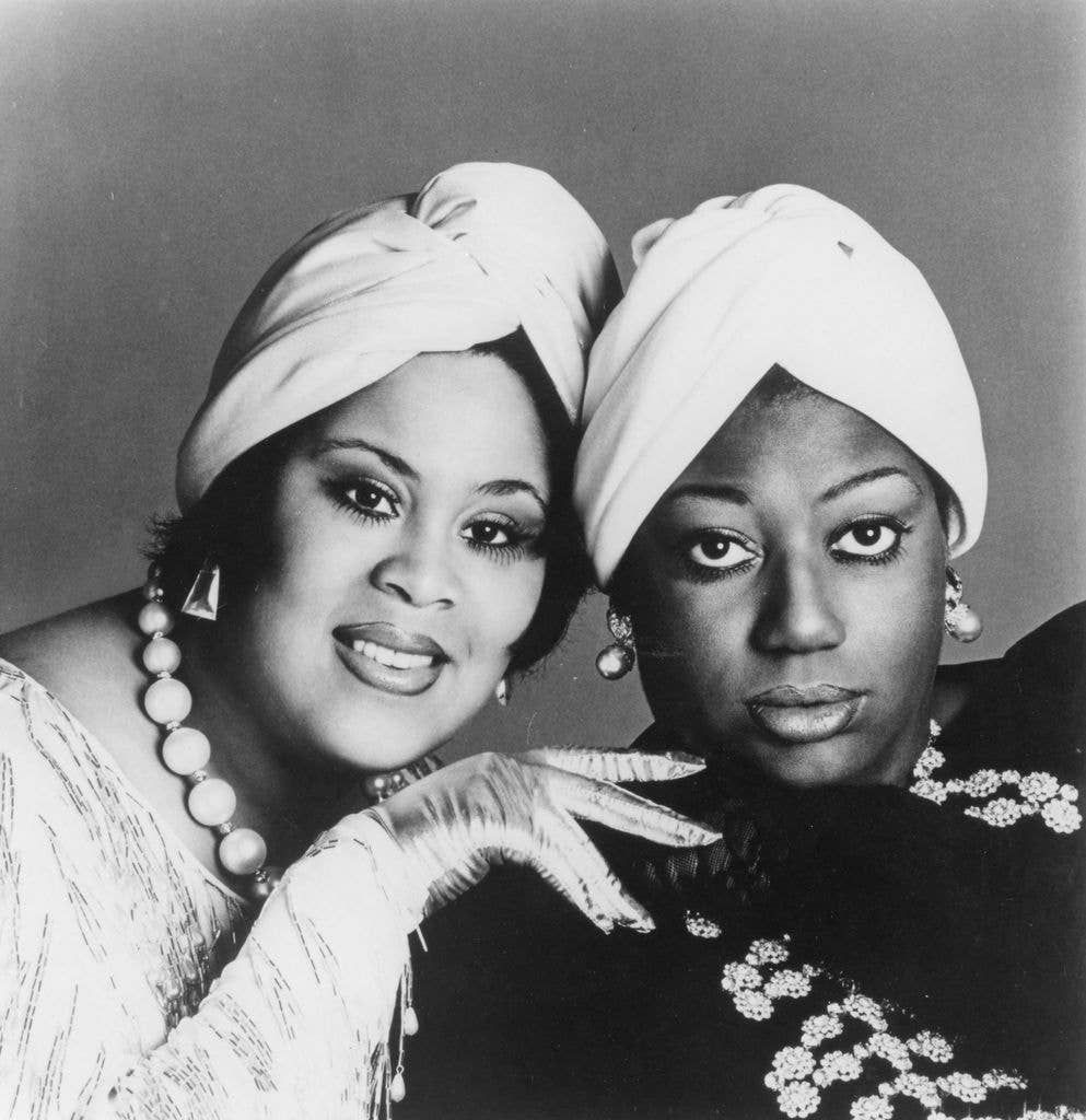Martha Wash and Izora Amrmstead in turbans, smiling and posing for a photo.