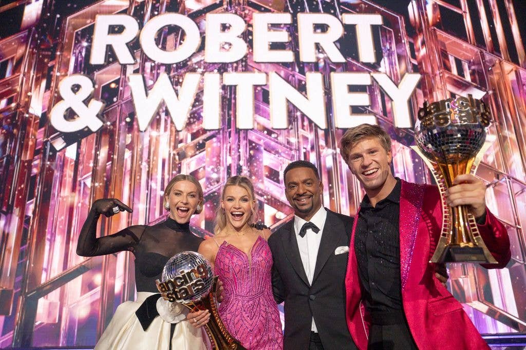 Julianne Hough, Alfonso Ribeiro, Witney Carson, and Robert Irwin holding trophies, smiling on stage.