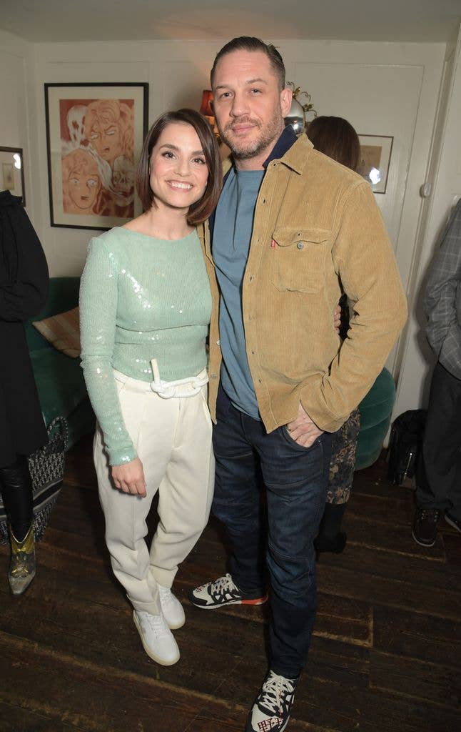 Charlotte Riley and Tom Hardy stand side by side and smile for a photo while visiting Soho House in London for an event
