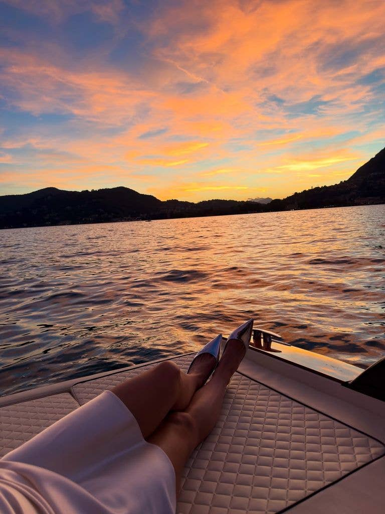 Katie showed off her legs in a satin skirt and silver heels on the edge of the boat
