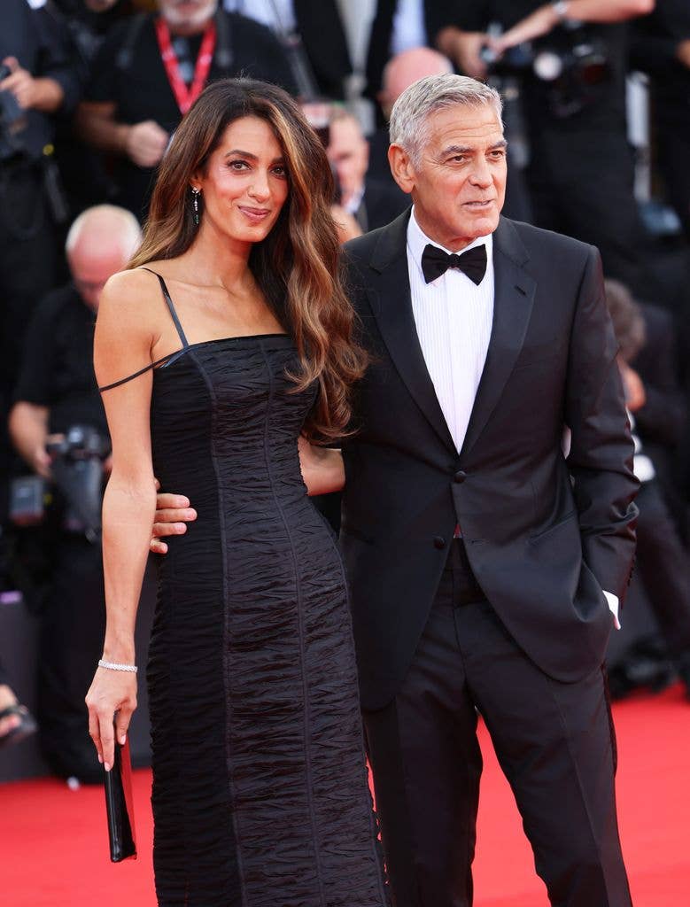 Amal and George Clooney with their arms around each other 