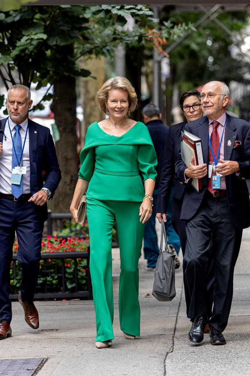 The Belgian queen paired her vibrant green ensemble with a neutral clutch and statement earrings for a day of engagements in New York.