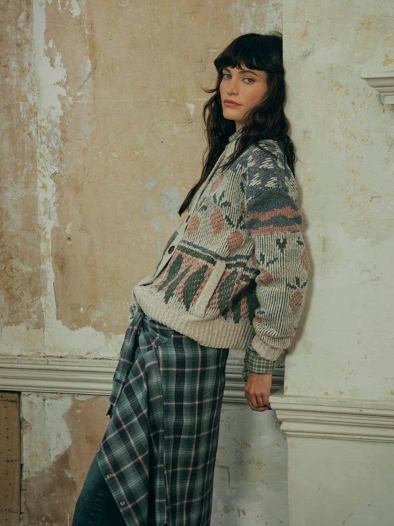 model wearing fatface cardigan leaning against wall