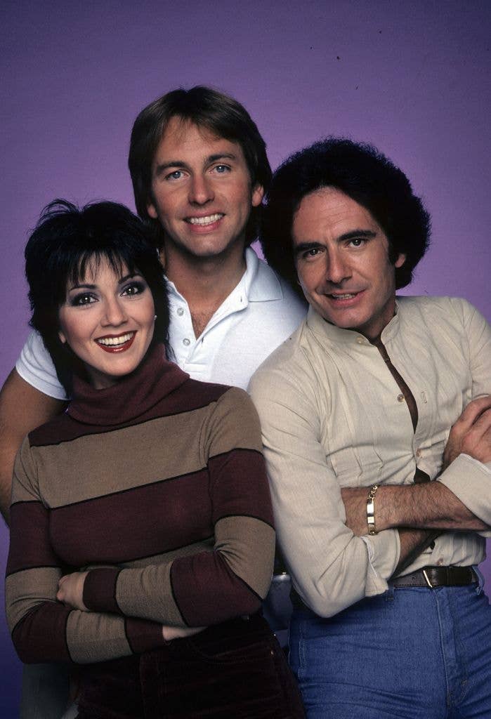 Joyce Dewitt, John Ritter and Richard Kline of Three's Company pose against a purple backdrop.