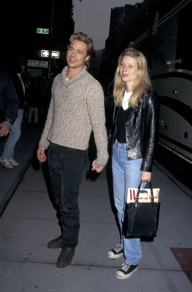 Brad Pitt and Gwyneth Paltrow in the 90s - both wearing jeans, while Gwyneth wears a black leather jacket and two tank tops layered together. 