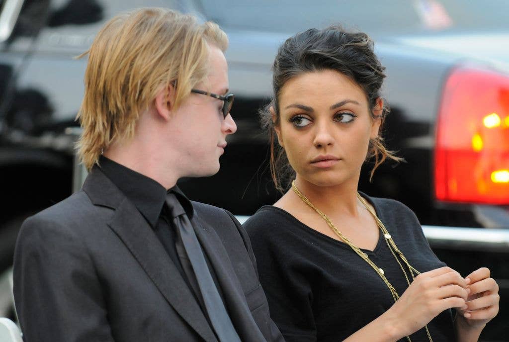 Mila Kunis and Macaulauy Culkin looking at each othet