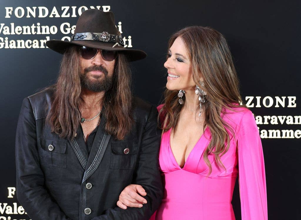 Elizabeth Hurley in pink smiling at Billy Ray Cyrus