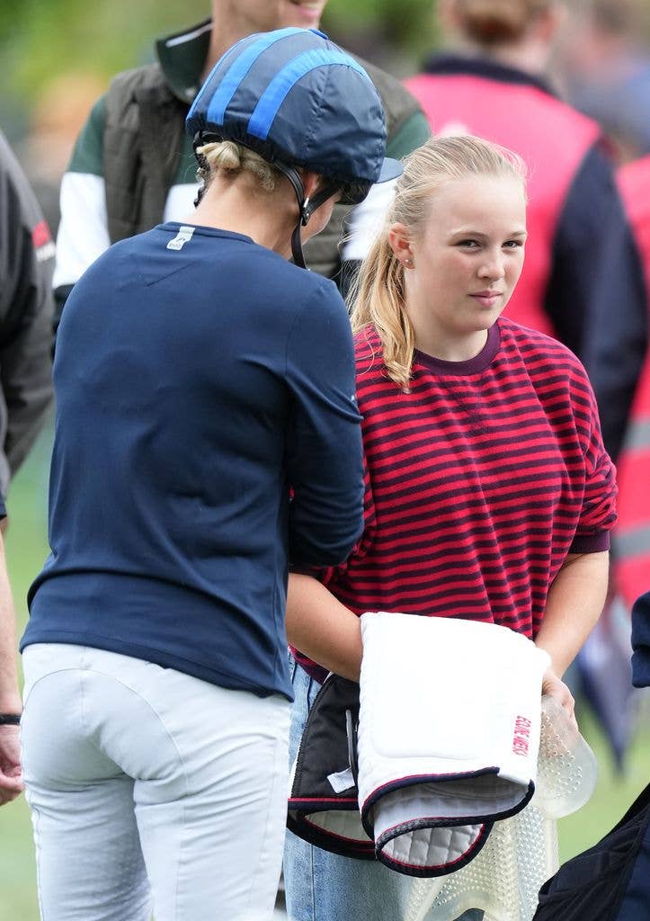 Mia Tindall stands holding riding equipment beside her mother Zara Tindall, who wears a riding helmet, after the cross country phase at Blenheim Palace.