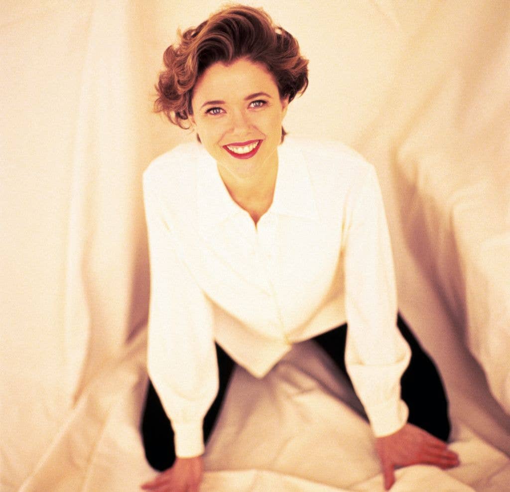 Actress Annette Being in a white shirt against a cream background.
