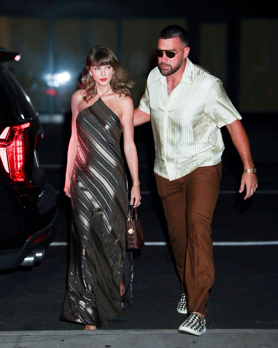Photo 2026 Backgrid/The Grosby Group
PREMIUM EXCLUSIVE
New York, Sept. 7, 2026
Taylor Swift and Travis Kelce were spotted heading to Ambassadors Clubhouse New York, an Indian restaurant in NoMad, for dinner. Taylor wore a Stella McCartney one-shoulder metallic striped dress with a draped silhouette, paired with a matching Stella McCartney handbag and strappy heels. Travis kept it casual in a striped short-sleeve shirt, brown trousers, sunglasses and checkered sneakers.****
Taylor Swift y Travis Kelce fueron vistos dirigiéndose a Ambassadors Clubhouse New York, un restaurante de comida india ubicado en NoMad, para cenar. Taylor lució un vestido metálico de rayas de Stella McCartney, de un solo hombro y con silueta drapeada, que combinó con un bolso a juego de Stella McCartney y sandalias de tacón con tiras. Travis mantuvo un estilo casual con una camisa de manga corta a rayas, pantalones cafés, gafas de sol y tenis a cuadros.