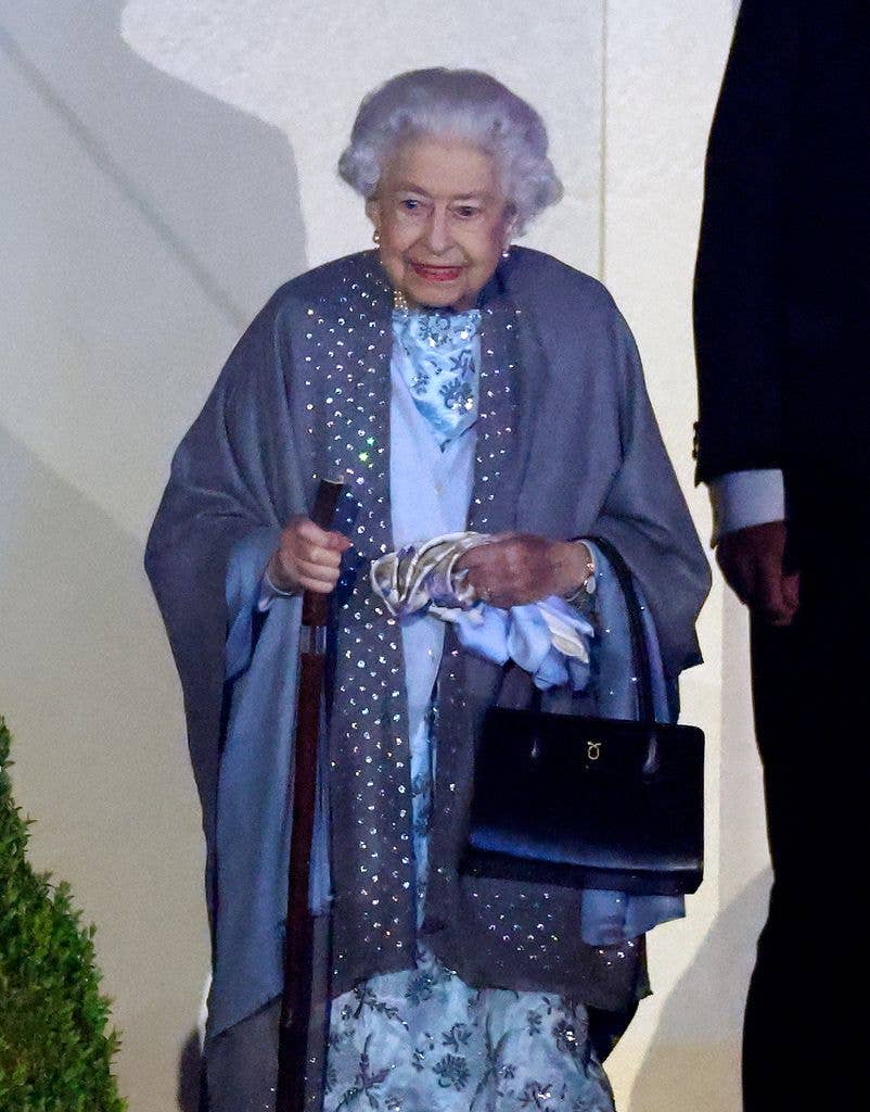 queen elizabeth with a walkng stick and shawl