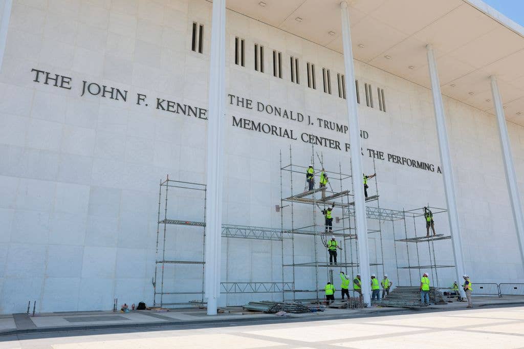 Construction workers build scaffolding near the sign for the Donald J. Trump and John F. Kennedy Memorial Center for the Performing Arts on June 12, 2026 in Washington, DC. The Kennedy Center board voted to seek an emergency appeal to block a court order requiring the removal of President Trump's name from the Kennedy Center, but a judge denied their request